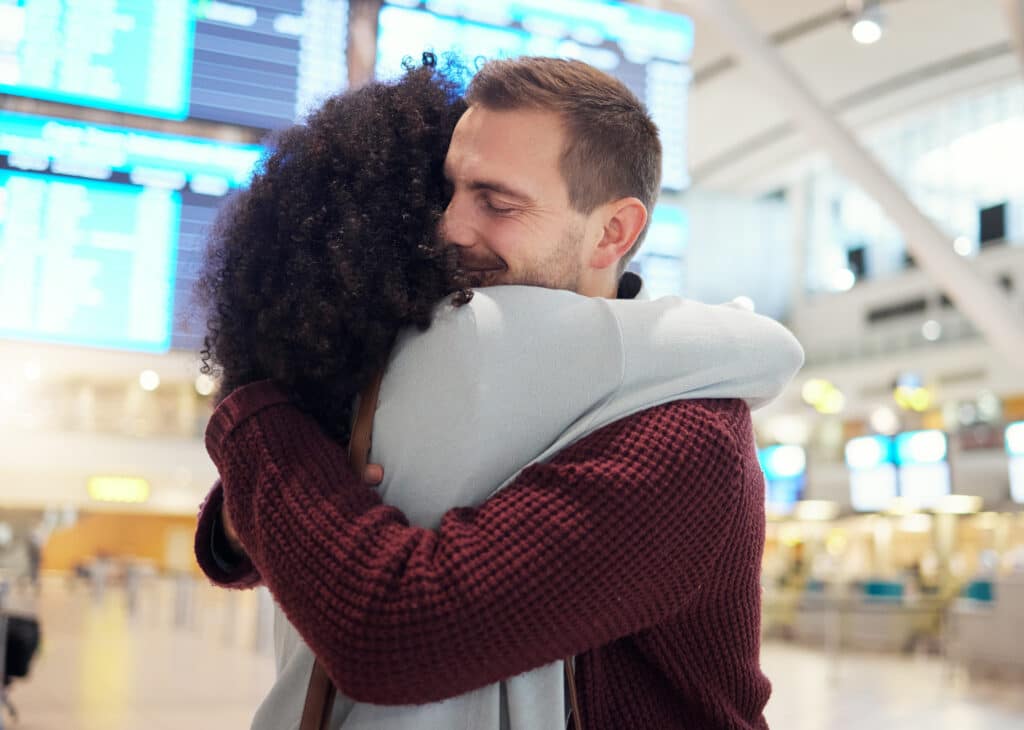 Couple, hug and farewell at airport for travel, trip or flight in goodbye for long distance relatio